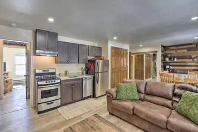 a living room with a couch and a kitchen at Walk to Marina Rustic Grand Lake Retreat! in Grand Lake