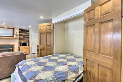 a bedroom with a bed and a large wooden door at Walk to Marina Rustic Grand Lake Retreat! in Grand Lake