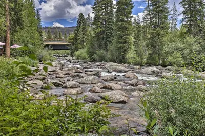 a river with rocks and a bridge in the background at Walk to Marina Rustic Grand Lake Retreat! in Grand Lake