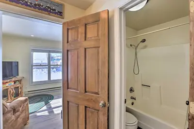 a door leading to a bathroom with a toilet at Walk to Marina Rustic Grand Lake Retreat! in Grand Lake