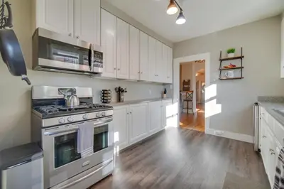 a kitchen with white cabinets and a stove at Charming Getaway, Walk to Windsor Lake and Downtown! in Windsor