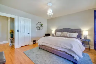 a bedroom with a large bed and a chandelier at Charming Getaway, Walk to Windsor Lake and Downtown! in Windsor