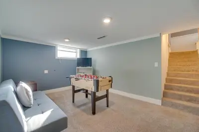 a living room with a couch and a foosball table at Charming Getaway, Walk to Windsor Lake and Downtown! in Windsor