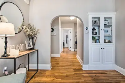 a hallway with white walls and a mirror and a table at Charming Getaway, Walk to Windsor Lake and Downtown! in Windsor