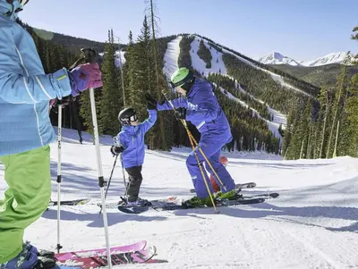 a group of people on skis in the snow at Premier 2BR 2BA in Lakeside Village- Kids Ski Free! condo in Keystone