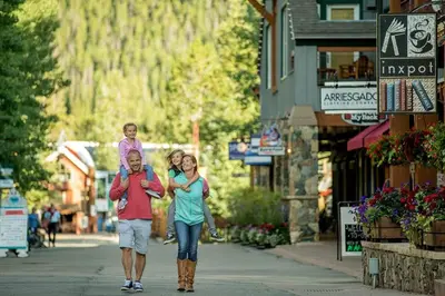 a man and woman walking down a street with a child at Premier 2BR 2BA in Lakeside Village- Kids Ski Free! condo in Keystone