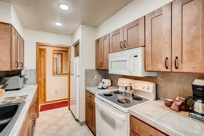 a kitchen with white appliances and wooden cabinets at Premier 2BR 2BA in Lakeside Village- Kids Ski Free! condo in Keystone