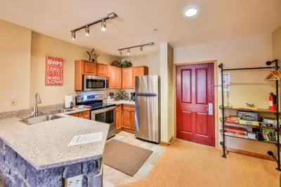a kitchen with a stainless steel refrigerator and a red door at Zephyr Slopeside - 1504 condo in Winter Park