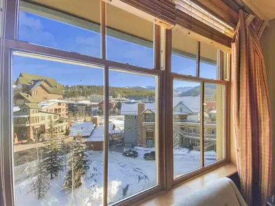 a large window with a view of a snowy town at Zephyr Slopeside - 1504 condo in Winter Park