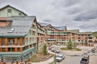 a group of buildings with cars parked in a parking lot at Zephyr Slopeside - 1504 condo in Winter Park