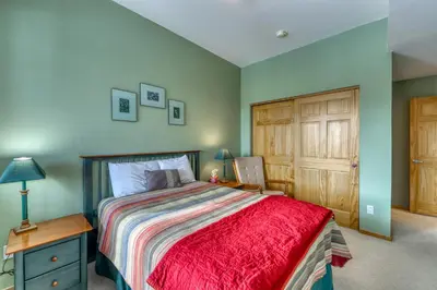 a bedroom with a bed and a wooden cabinet at Cydney Ln 61C in Silverthorne