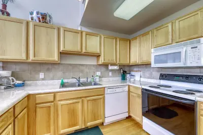 a kitchen with wooden cabinets and white appliances at Cydney Ln 61C in Silverthorne