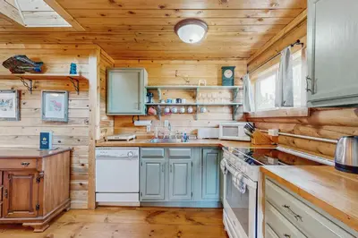 a kitchen with wooden walls and wooden counters at Grand Lake Cabin Escape in Grand Lake