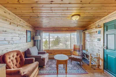 a living room with a couch and chairs and a window at Grand Lake Cabin Escape in Grand Lake