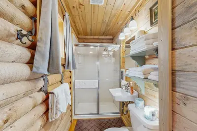 a bathroom with a shower and a toilet and a sink at Grand Lake Cabin Escape in Grand Lake