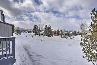 a snow covered yard with trees and buildings at Cozy Fraser Mtn Retreat with Shuttle to Winter Park in Fraser