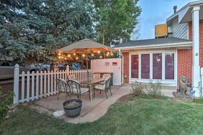 a patio with a table with chairs and an umbrella at Private Yard and Patio Denver Area Home! in Northglenn