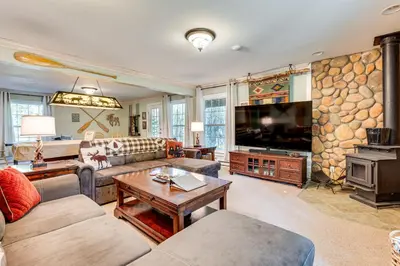 a living room with a couch and a tv at Secluded Log Cabin with Game Room and Forest Views in Red Feather Lakes