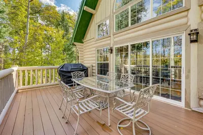 a patio with a table and chairs on a deck at Secluded Log Cabin with Game Room and Forest Views in Red Feather Lakes
