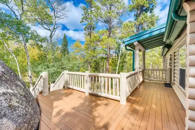 a porch of a house with a wooden deck at Secluded Log Cabin with Game Room and Forest Views in Red Feather Lakes