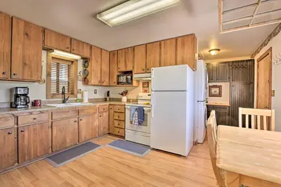 a kitchen with wooden cabinets and a white refrigerator at Fireplace, Deck and Mtn Views Grand Lake Home! in Grand Lake