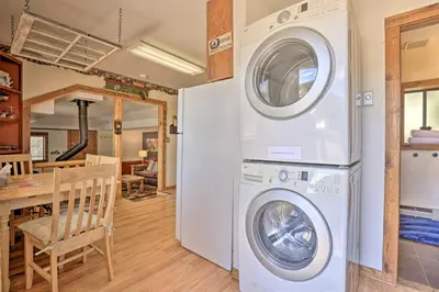 a kitchen and dining room with a washer and dryer at Fireplace, Deck and Mtn Views Grand Lake Home! in Grand Lake