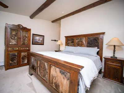 a bedroom with a large bed and wooden furniture at Taharaa Mountain Lodge in Estes Park