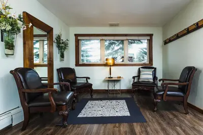 a waiting room with chairs and a table and a window at Taharaa Mountain Lodge in Estes Park