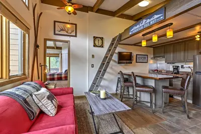 a living room with a red couch and a kitchen at Walk to Village Condo with Resort Perks in Keystone in Keystone