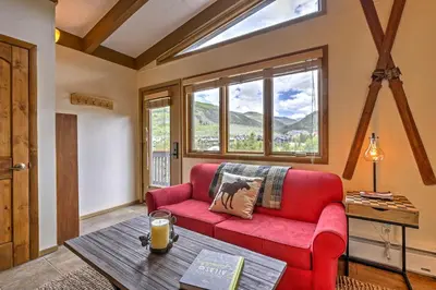 a living room with a red couch and a table at Walk to Village Condo with Resort Perks in Keystone in Keystone