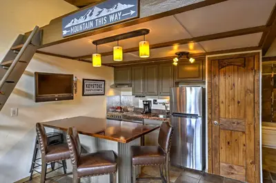 a kitchen with a table and a refrigerator at Walk to Village Condo with Resort Perks in Keystone in Keystone