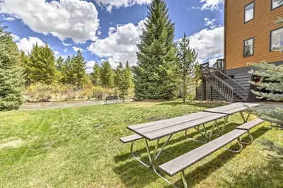 a picnic table in the grass next to a building at Walk to Village Condo with Resort Perks in Keystone in Keystone