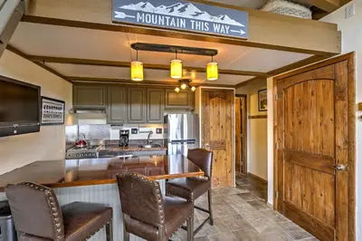 a kitchen with a bar with chairs and a counter top at Walk to Village Condo with Resort Perks in Keystone in Keystone