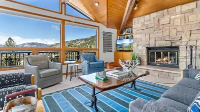 a living room with a large stone fireplace at Primavista Luxury Home at Windcliff condo in Estes Park