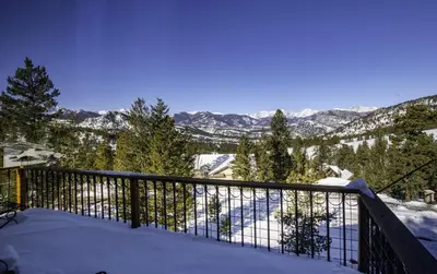 a snow covered balcony with a view of the mountains at Primavista Luxury Home at Windcliff condo in Estes Park