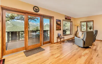 a living room with large windows and a chair at Divine Destiny Luxury Home at Windcliff condo in Estes Park