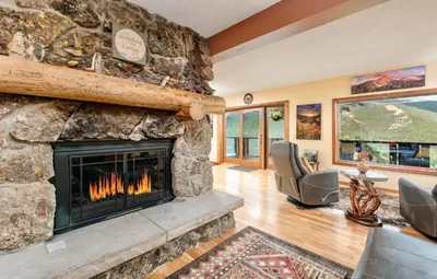 a living room with a large stone fireplace at Divine Destiny Luxury Home at Windcliff condo in Estes Park