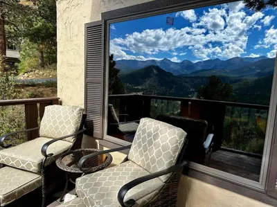 two chairs on a balcony with a view of mountains at Divine Destiny Luxury Home at Windcliff condo in Estes Park
