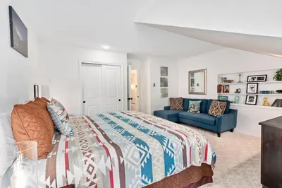 a bedroom with a bed and a blue couch at Divine Destiny Luxury Home at Windcliff condo in Estes Park