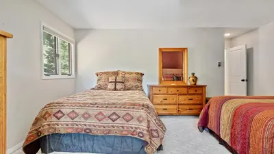 a bedroom with two beds and a dresser and a mirror at Divine Destiny Luxury Home at Windcliff condo in Estes Park