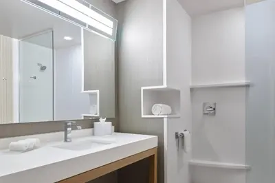 a bathroom with a sink and a mirror and a shower at Courtyard Denver Aurora in Aurora