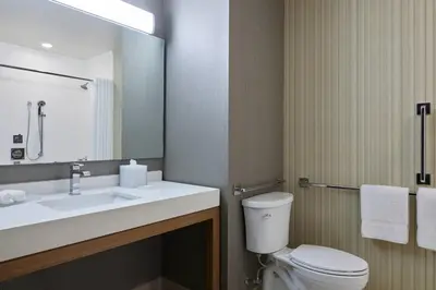 a bathroom with a sink and a toilet and a mirror at Courtyard Denver Aurora in Aurora