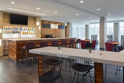 a restaurant with a bar with chairs and tables at Courtyard Denver Aurora in Aurora