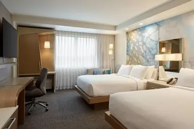 a hotel room with two beds and a desk at Courtyard Denver Aurora in Aurora