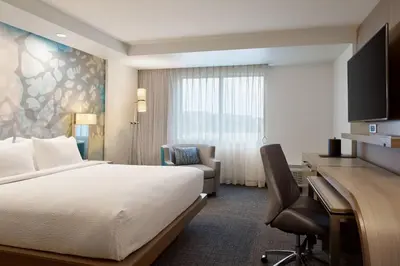 a hotel room with a bed and a desk at Courtyard Denver Aurora in Aurora