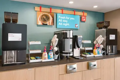 a coffee shop with a counter with a coffee machine at Avid Hotels - Denver Airport Area by IHG in Denver