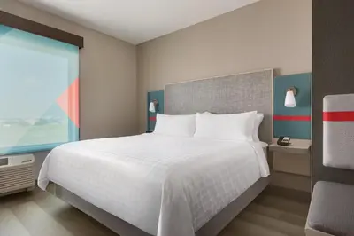 a bedroom with a large white bed and a window at Avid Hotels - Denver Airport Area by IHG in Denver