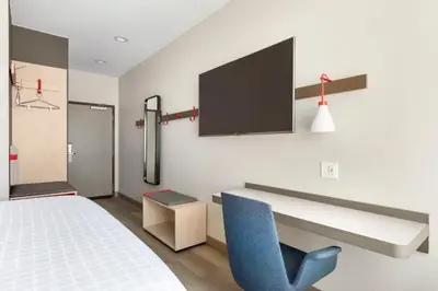 a room with a bed and a blue chair at Avid Hotels - Denver Airport Area by IHG in Denver