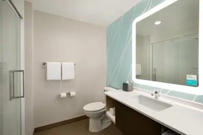a bathroom with a sink and a toilet and a mirror at Avid Hotels - Denver Airport Area by IHG in Denver