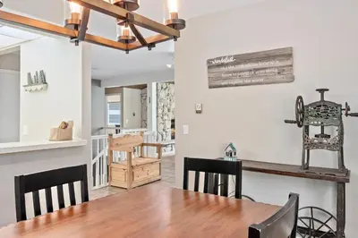a dining room and kitchen with a wooden table and chairs at Wanderlust Luxury Vacation Home at Windcliff condo in Estes Park